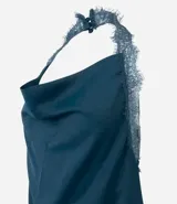 Blusa frente única de satén color verde petróleo, con escote degagê y detalles de encaje en los bordes y ruedo asimétrico.