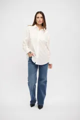 Camisa de corte clásico y calce holgado, con cuello camisero, cierre frontal con botones y mangas largas con puños abotonados.