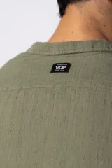 Camisa de manga larga confeccionada en tejido de lino con textura, de corte holgado y diseño versátil con cierre frontal de botones.