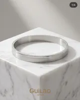 Esclava rígida de acero inoxidable con diseño minimalista de superficie lisa y acabado pulido.