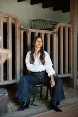 Camisa de lino de corte relajado y silueta holgada, con cuello clásico y cierre frontal de botones forrados en lino a rayas. Presenta mangas largas con puños amplios.