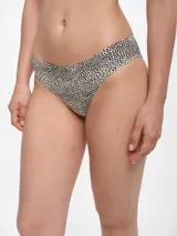 Bombacha de bikini con estampado de manchas negras sobre fondo beige.