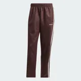 Pantalón deportivo Adidas color marrón, con diseño de monograma grabado en relieve en todo el tejido, franjas laterales blancas y el logo de la marca bordado en la cadera.