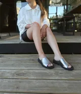 Sandalias chatas de cuero color peltre, fabricadas en Uruguay.