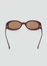 Gafas de sol con diseño ovalado y montura de pasta en tono rojizo oscuro. Cuentan con cristales marrones y protección UV categoría 3.