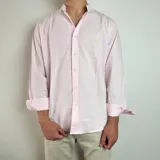 Camisa de algodón con estampado de rayas verticales finas en color blanco y rosado. Presenta cuello mao, cierre frontal con botones y mangas largas.