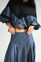 Falda larga negra con diseño de caderín y tablas.