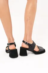Sandalias negras de cuero con plataforma y taco cuadrado forrado. Presentan doble tira ancha sobre el empeine y tira con hebilla al tobillo.