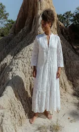 Vestido largo blanco de broderie con escote en V y mangas 3/4 amplias.
