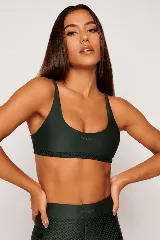 Top deportivo color verde oscuro, con tirantes finos y espalda descubierta. Diseño reversible con un lado brillante y otro con textura 3D tipo colmena.