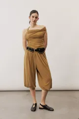 Pantalón holgado negro tipo bombacho, con cintura elástica y puños fruncidos en los tobillos.