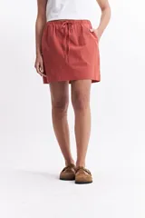 Falda corta de color negro, confeccionada en algodón liviano. Presenta una cintura elastizada con lazo ajustable y bolsillos laterales.