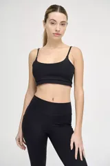 Top deportivo negro con tirantes finos regulables y banda elástica bajo el busto.
