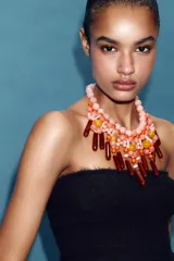 Collar de diseño llamativo compuesto por múltiples cuentas de resina en diversas formas, tamaños y tonalidades de rosa, naranja y marrón oscuro, con cierre de mosquetón.