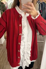 Saco tejido de punto con diseño a rayas verticales en tonos bordó y violeta. Presenta cuello redondo, cierre frontal con botones de madera y mangas largas con puños acanalados.