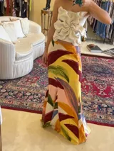 Falda larga de corte sirena con estampado artístico multicolor en tonos amarillos, bordó, verdes y naranjas.
