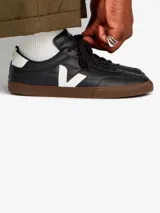 Championes urbanos Veja modelo Panenka, color negro con detalles en blanco y suela de goma color marrón. Presentan el logo lateral en forma de V y cierre con cordones.