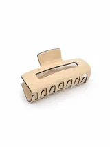 Pinza para el pelo tipo clip de diseño rectangular con acabado brillante en color beige y bordes en contraste negro.