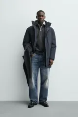 Parka acolchada impermeable color gris oscuro, de corte regular fit, con cuello doble subido, bolsillos de vivo en la cadera y cierre frontal con cremallera oculta por solapa con botones a presión.