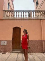 Vestido corto rojo con cuello polo, cierre frontal con cremallera y diseño calado.