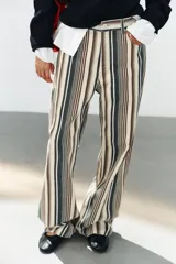 Jeans de tiro medio con diseño de rayas verticales en tonos beige, marrón y verde, corte boyfriend, cinco bolsillos y cierre frontal con cremallera y botón.