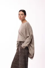 Sweater de punto con silueta amplia y relajada, cuello redondo y mangas largas con puños ajustados. Presenta un diseño de caída fluida y tejido suave.