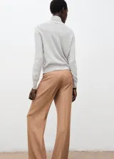 Jersey de punto fino color gris claro, de corte recto y manga larga, con cuello alto y detalle de lazada en el cuello.