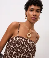 Vestido midi evasê sin mangas, con breteles finos, escote recto, lastex en la espalda y ruedo con recortes fruncidos. Estampado con animal print de leopardo.