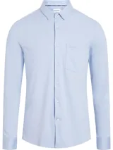 Camisa celeste de algodón orgánico, corte slim fit, con cierre frontal de botones, bolsillo de parche en el pecho y logo de Calvin Klein en el lateral.