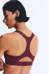 Top deportivo color vino tinto, de tejido funcional con tecnología ShapeMove™ y DryMove™, corte ajustado, escote cuadrado al frente y espalda nadadora en malla con cut-out. Presenta copas forradas con relleno extraíble y breteles anchos ajustables.