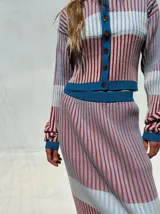 Falda midi de punto acanalado con diseño multicolor de rayas verticales en tonos rosado, rojo, celeste y blanco, con pretina elástica de tiro alto y corte tipo lápiz.