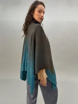 Ruana de lana merino tejida, teñida y estampada, con cuello plisado en fieltro de lana merino.