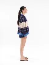 Cardigan tejido de punto jacquard en tonos bordó y rojo con rayas, de corte oversize, cuello redondo y cierre frontal con botones carey. Presenta detalles bordados en contraste y monograma en la espalda.