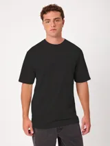 Remera holgada Rusty de color negro con lavado ácido, cuello ancho redondo y mangas cortas. Presenta un pequeño estampado sutil en el pecho.