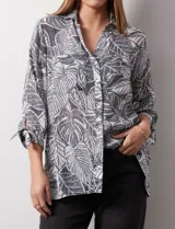 Camisa estampada con hojas, marca Ruby Rd. Cuello con solapa y abertura central con botones. Delantera con bolsillos aplicados. Manga 3/4 con lazo.