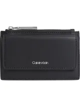 Tarjetero minimalista negro de Calvin Klein con bolsillo exterior con cierre de solapa, monedero con cremallera y múltiples ranuras para tarjetas.