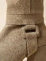 Botas de caña alta desmontables color visón, confeccionadas en gamuza natural. Presentan un diseño de punta semi cuadrada, taco ancho de 6 cm y detalle de estribo con hebilla forrada en la base.