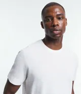 Remera de hombre, corte regular, color blanco, con cuello redondo y mangas cortas. Presenta una textura diferenciada en el tejido de media malla.