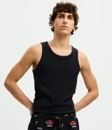 Pantalón de pijama de plush color negro con estampado de autos rojos, corte holgado, cintura elástica con cordón de ajuste y puños en los tobillos.