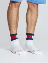 Pack de tres pares de medias de caña media, confeccionadas en tejido de algodón con detalles distintivos de la marca. Presentan un diseño con franjas horizontales en azul, blanco y rojo en el puño elástico y el logo de Tommy Hilfiger bordado en la parte superior del pie.