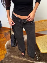 Jean de corte baggy con cintura cruzada asimétrica y diseño de tiro bajo, confeccionado en denim de color negro lavado.