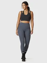 Top deportivo negro de sujeción media, confeccionado en tejido suave y elástico con Aloe Vera. Presenta un diseño de espalda cruzada y dos tiras con aberturas en los hombros.