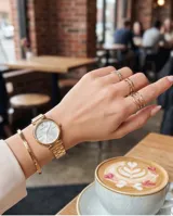 Reloj analógico Mini Focus con caja de metal dorada y esfera de nácar. Cuenta con movimiento de cuarzo japonés y malla de eslabones metálicos dorados con cierre desplegable.