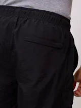 Bermuda cargo Rusty de corte recto, confeccionada en poliamida con acabado texturizado. Presenta cintura elástica con cordón de ajuste, bolsillos laterales tipo cargo con solapa y bolsillos frontales.