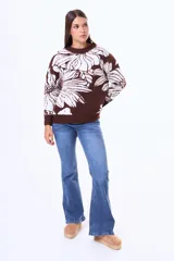 Buzo tejido de punto con diseño floral estampado en contraste, cuello redondo y terminaciones en rib. Presenta un calce holgado y mangas largas.