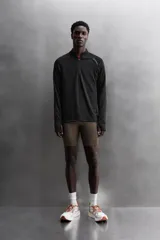 Sudadera negra de tejido técnico Polartec© con interior en estructura waffle. Tiene cuello alto con cremallera, mangas largas con puños ajustables con abertura para el pulgar y logo Polartec© bordado en el hombro.