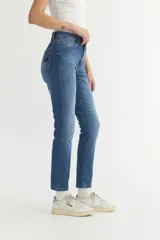 Jean de tiro alto color azul medio, corte recto y tobillos al descubierto.