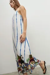 Maxi vestido blanco con rayas verticales azules y estampado de paisaje en el ruedo.