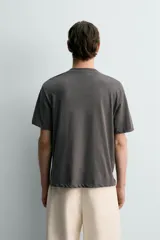 Camiseta de corte relaxed fit, confeccionada en mezcla de algodón y lino, con cuello redondo y mangas cortas.