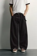 Pantalón barrel fit de mezclilla color verde militar, con efecto lavado, cinco bolsillos, cierre frontal con cremallera y botón, y detalle de pinzas en las rodillas.